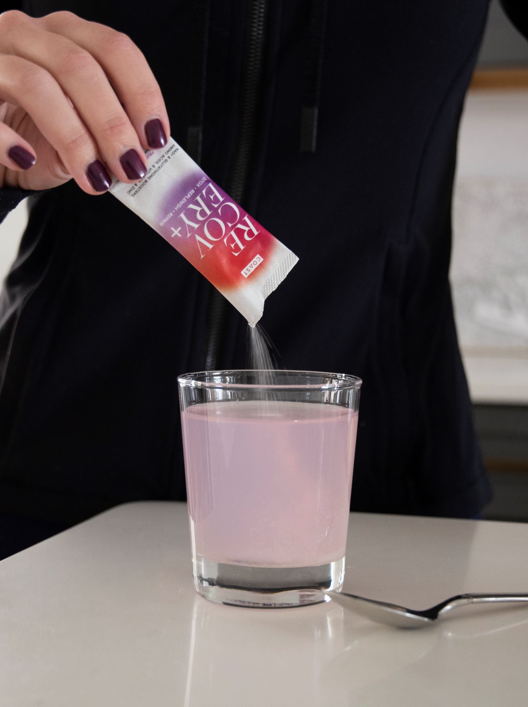 COAST Recovery+ powder stick being poured into glass of water. Drink COAST Recovery+ daily to recover better by flushing out toxins, replenishing lost nutrients, and repairing cells. NAD+ and glutathione.